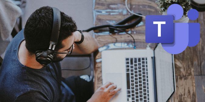 male sitting in front of laptop with headphones on