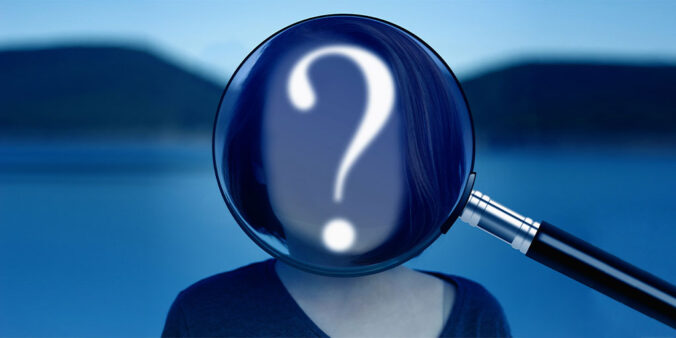 question mark and magnifying glass over blurred face
