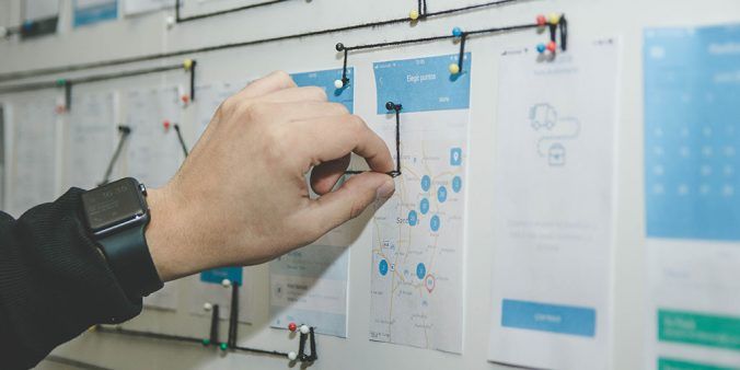 Person designing user design on blue and white board