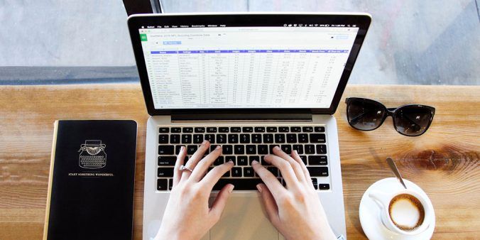 hands on laptop keyboard, editing a spreadsheet