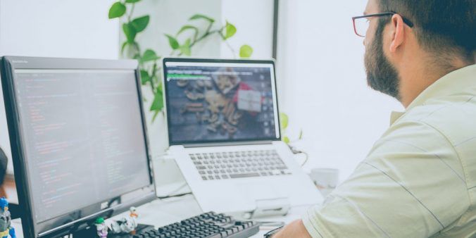 male working on laptop with second screen