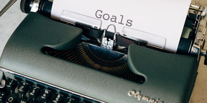 paper with 'goals' printed coming out of a typewriter