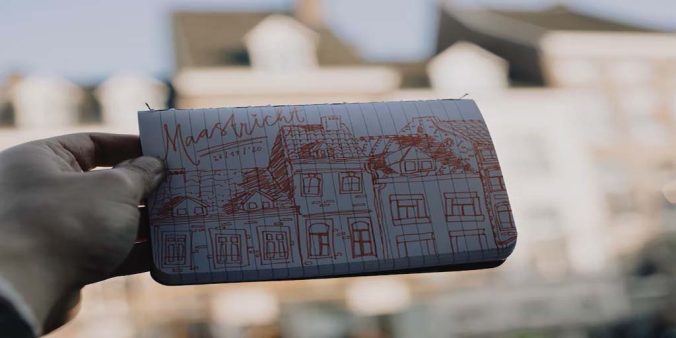 A reference image of a building being held in front of a building